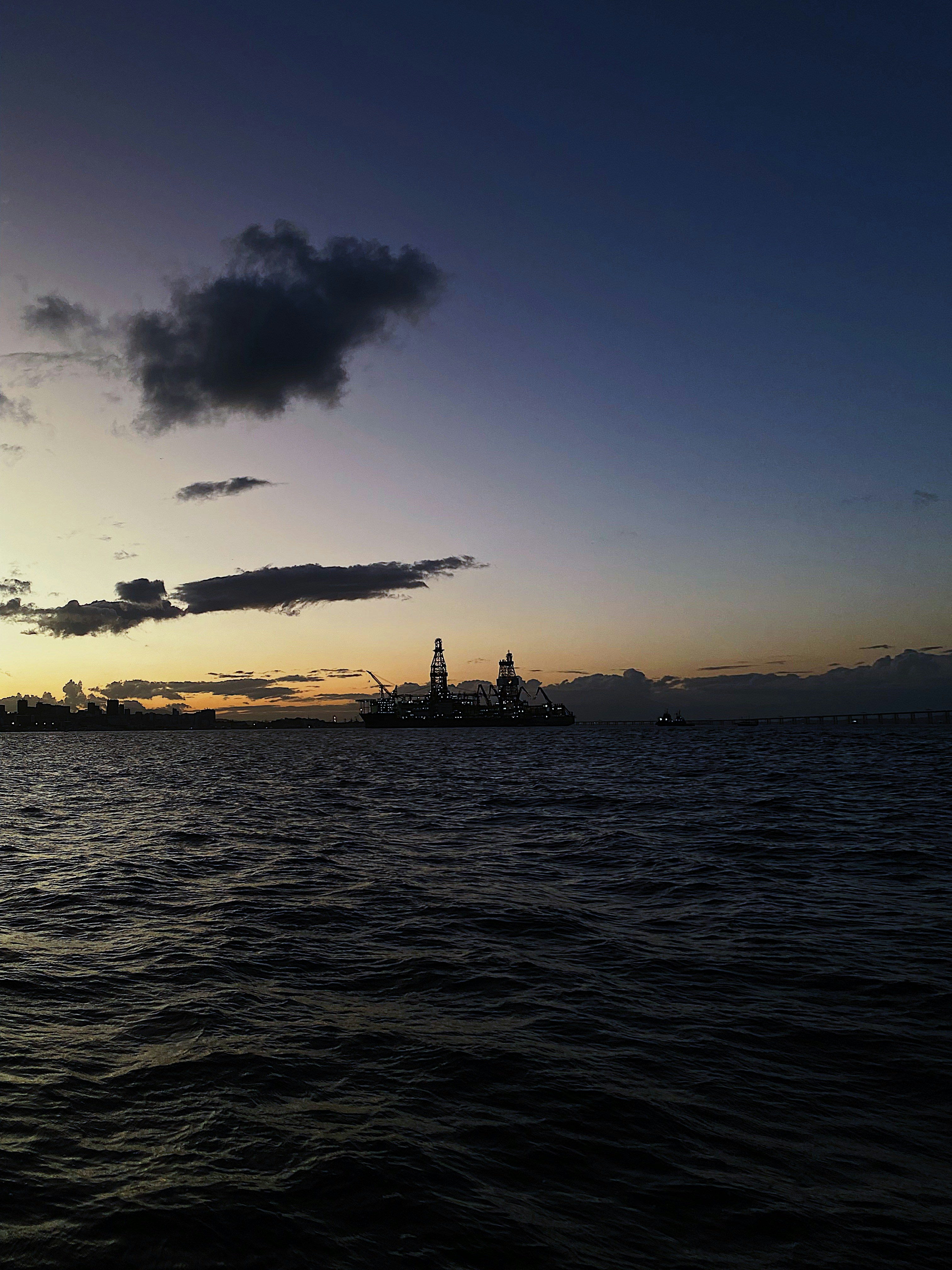 Offshore oil platform at sea, dark ocean water, industrial steel structure, dim atmospheric lighting