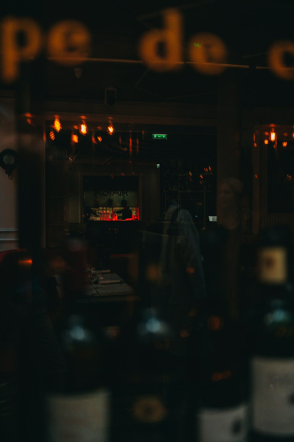 a bar with a tv and a window with lights