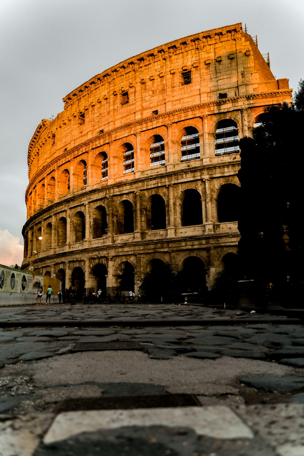 a large stone building with Colosseum in the background