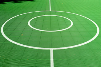 Finished sports court glowing under neon green lighting, showcasing sharp lines and clean surfaces.