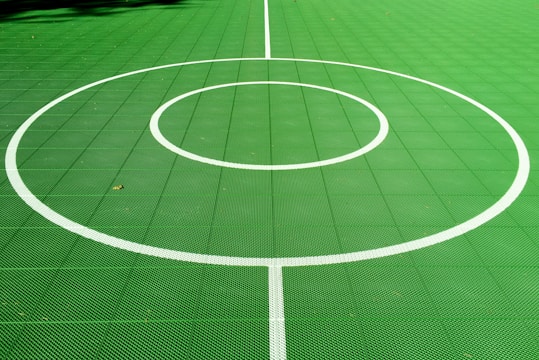 A freshly built sports court with vibrant markings under a clear sky.