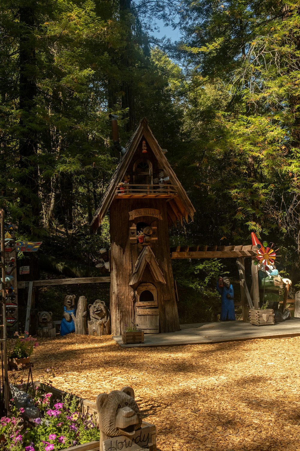 a wooden building with statues in front of it