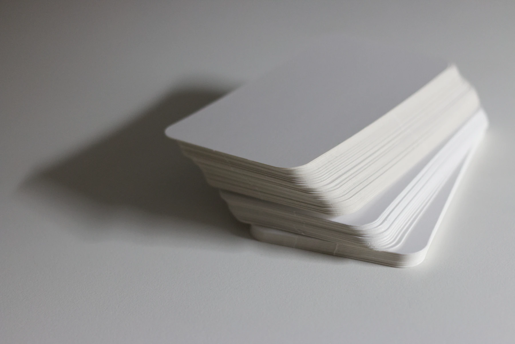 A stack of blank white cards on a white surface