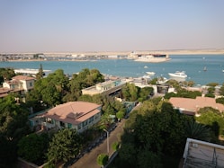 Aerial shot of the entire Sunshine Bay Residence complex nestled by the water, surrounded by greenery.