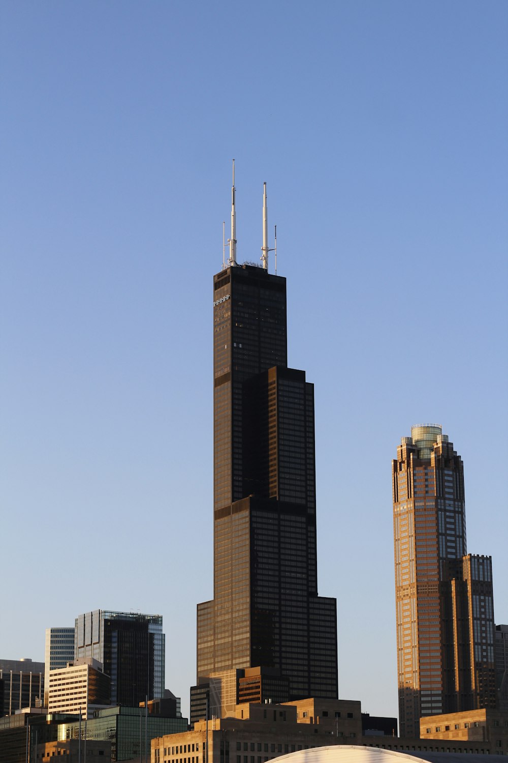 a couple of tall buildings with Willis Tower in the background