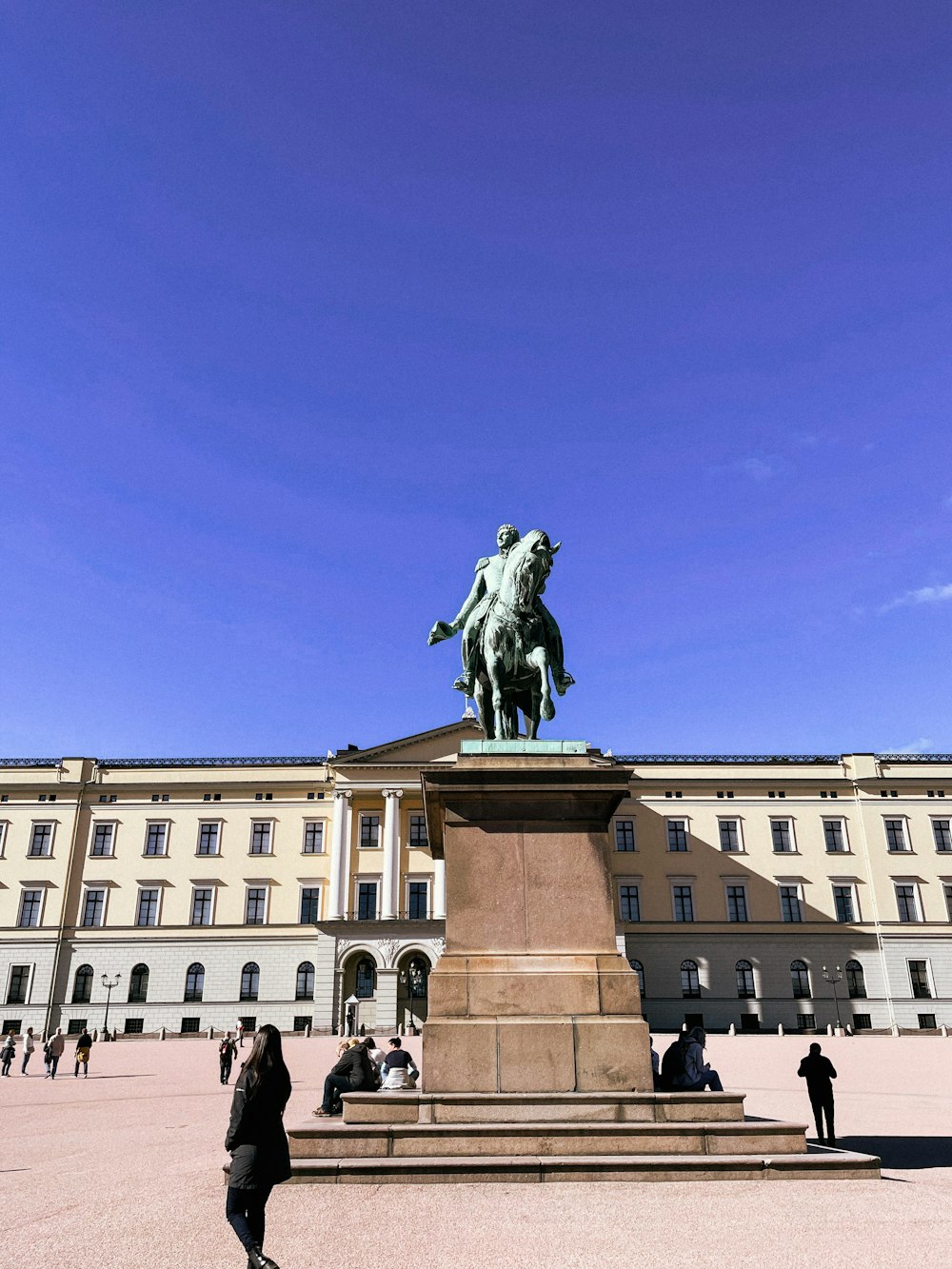 a statue of a person riding a horse in front of a building