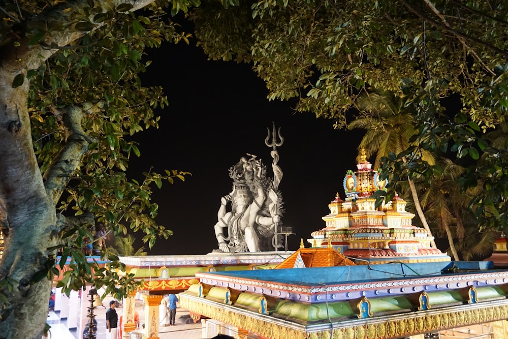 a statue of a person holding a torch in front of Batu Caves