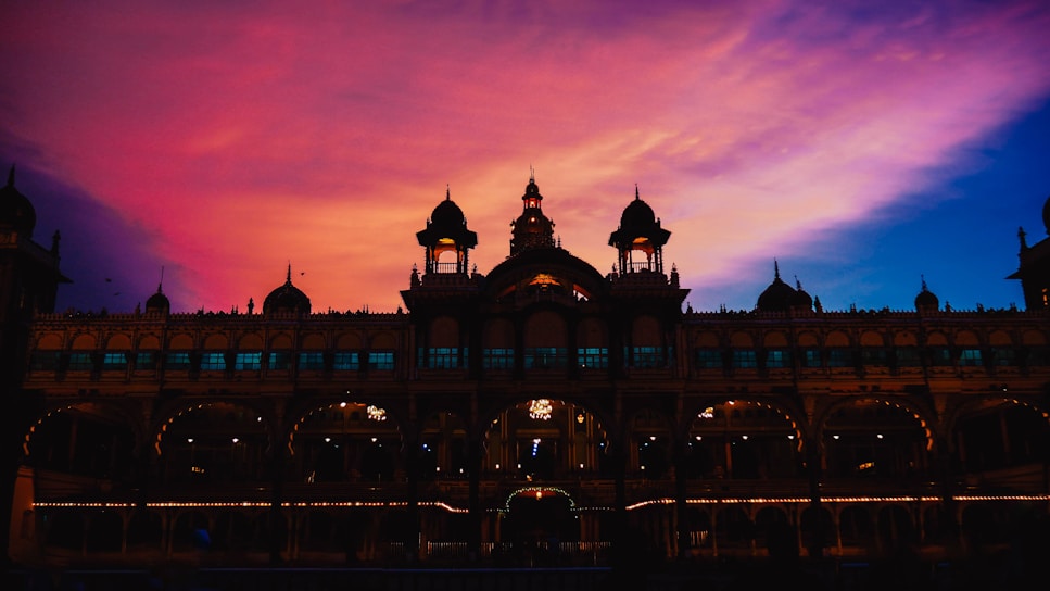 A stunning sunset view of the Hawa Mahal from the rooftop of Jai Kutir Homestay, with warm golden hues lighting up the historic facade.