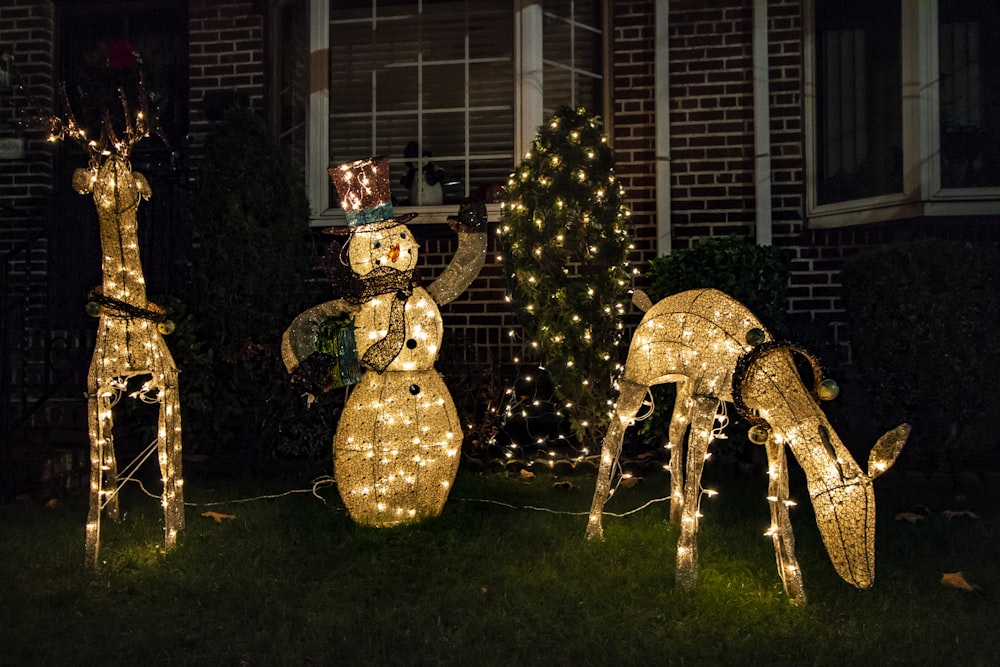 a group of deer statues in front of a house