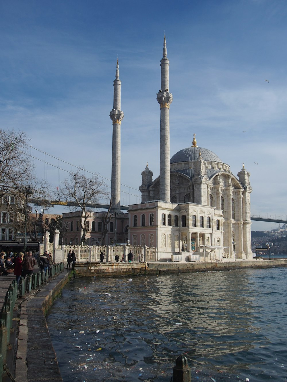 a building with a dome and towers by a body of water
