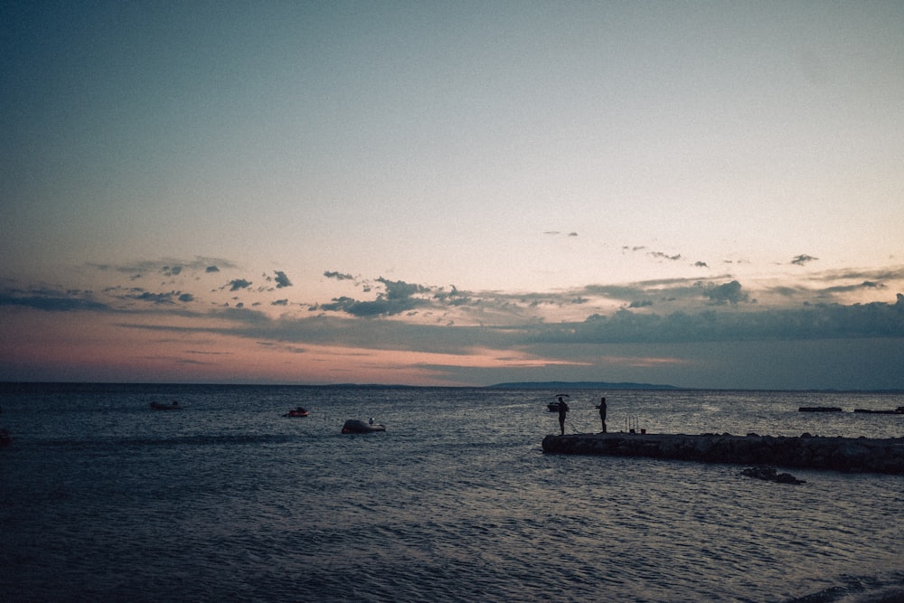 a group of people standing on rocks in the water