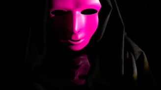 The statement mask displayed on a dark pedestal with gentle purple lighting emphasizing its contours.