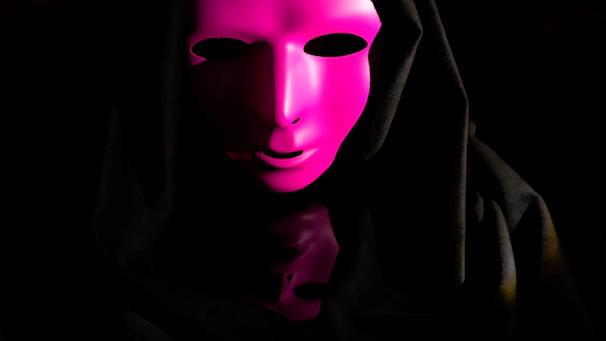 The statement mask displayed on a dark pedestal with gentle purple lighting emphasizing its contours.