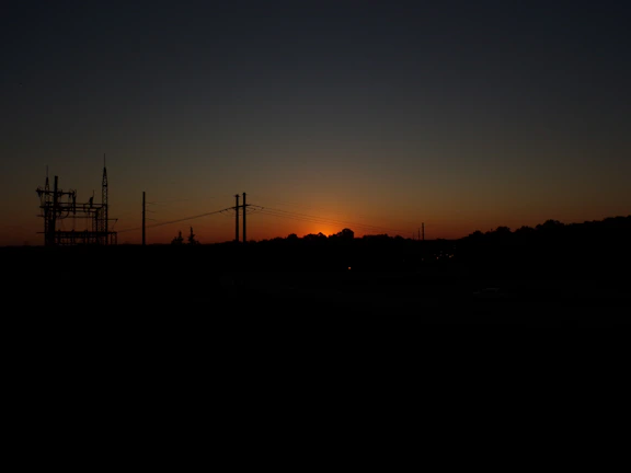 Sunset over the solar park with the grid connection infrastructure silhouetted.