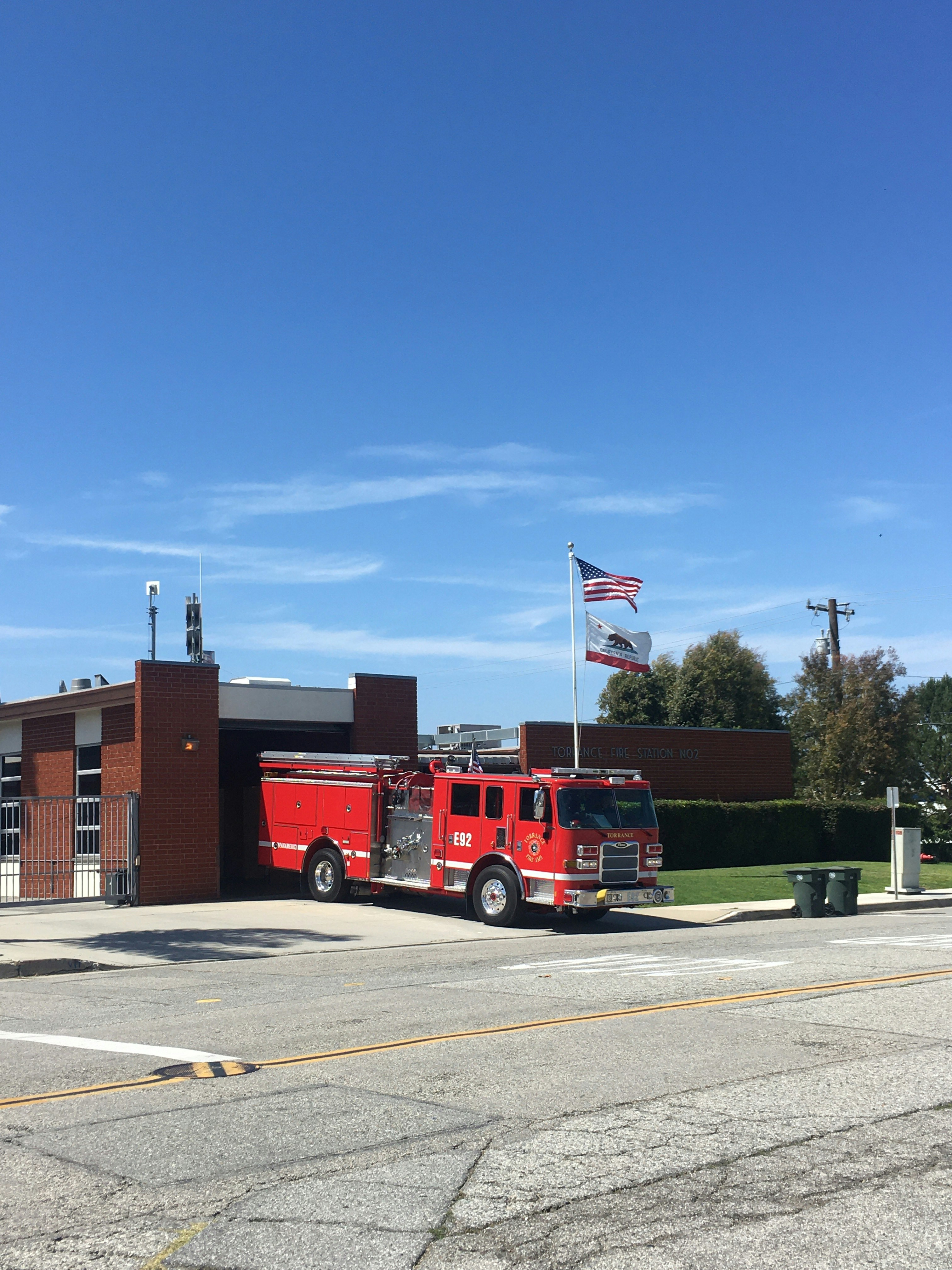a fire truck parked in front of a building with flags