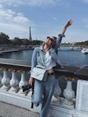 A joyful solo traveler taking photos near the Eiffel Tower on a bright day