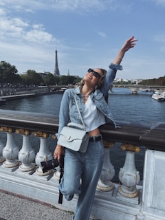 A happy traveler posing near the Eiffel Tower, holding a Schengen tourist visa.
