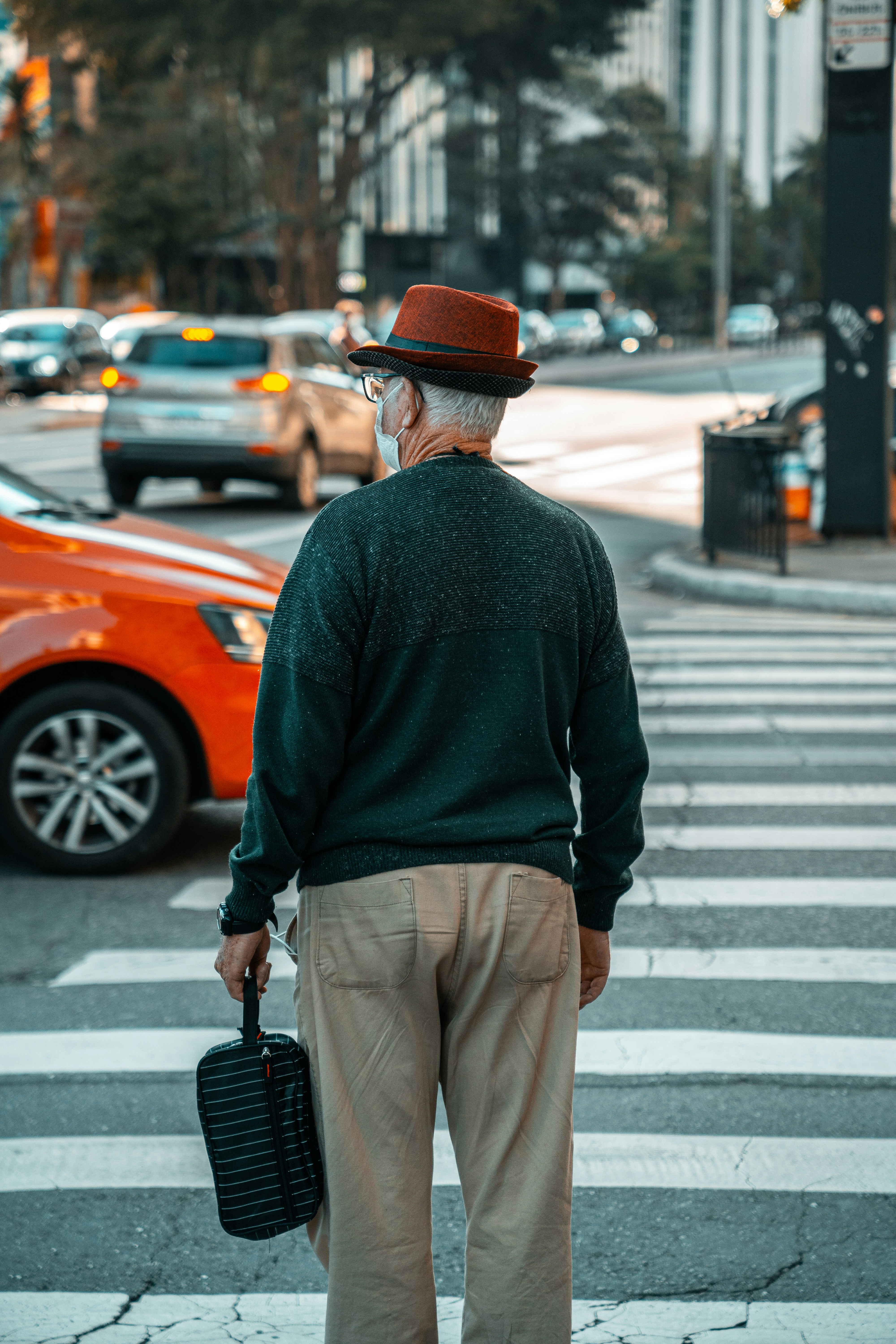 a man in a hat and coat holding a briefcase