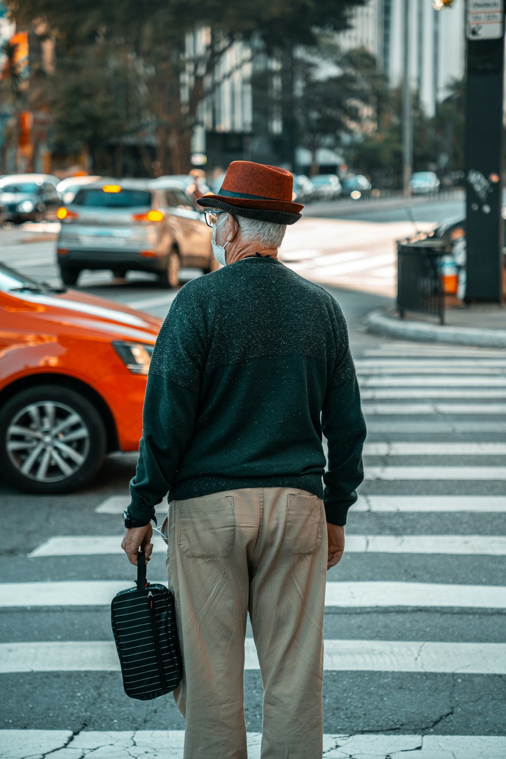 Un uomo con un cappello e un cappotto che tiene una valigetta