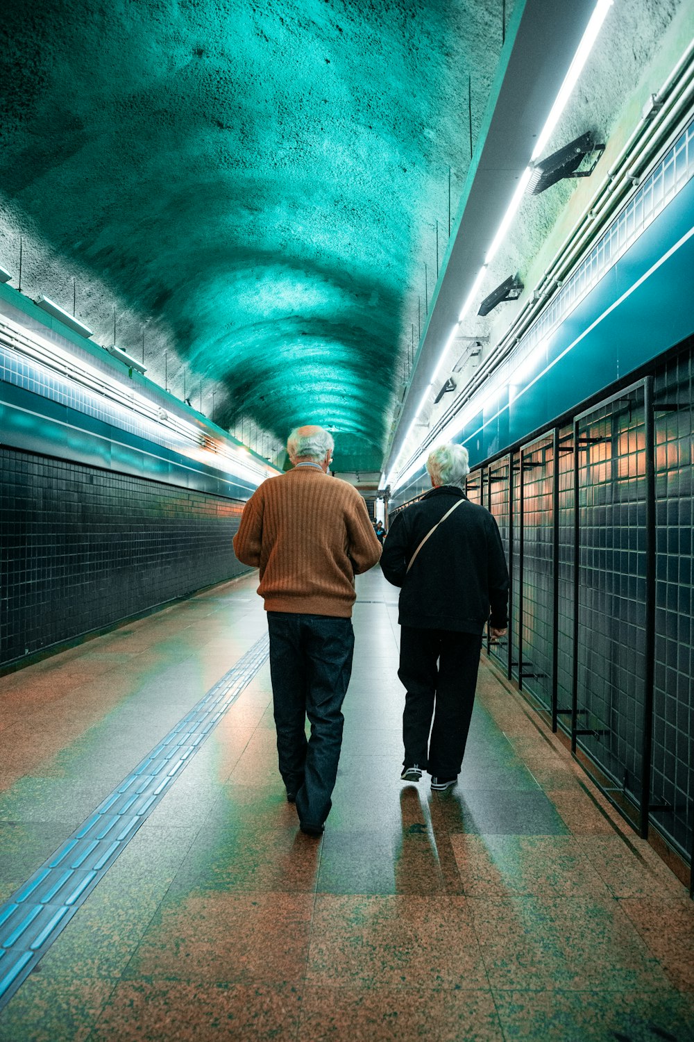 a couple of people walking down a tunnel