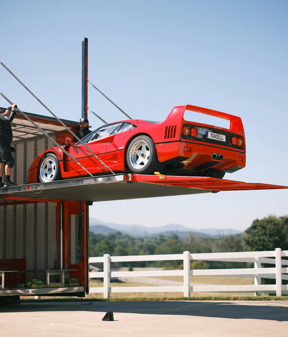 a red sports car on a wooden platform