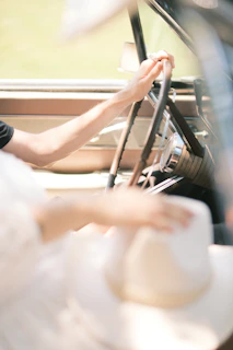 Close-up of a worn leather steering wheel with a Libertad Ruda hat resting on the dashboard.