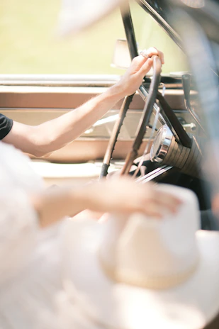 Close-up of a worn leather steering wheel with a Libertad Ruda hat resting on the dashboard.