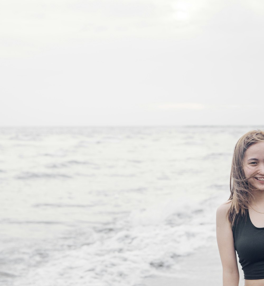 a woman standing in front of a body of water