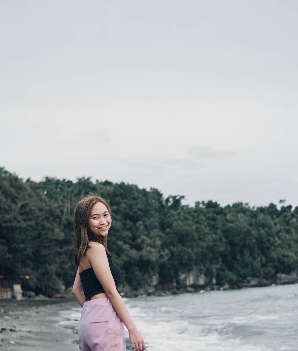 a woman standing in front of a body of water