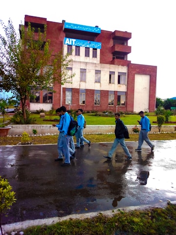 Students in blue and gold uniforms collaborating outdoors on a sunny day.
