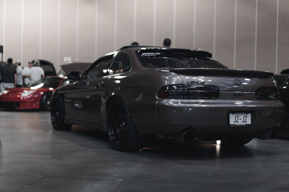 a black car parked in a showroom with other cars