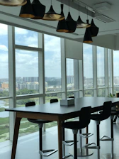 A team collaborating over contract documents in a modern office with city views of Basra and Dubai.