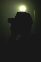 A cinematic night scene featuring a steampunk hat illuminated by soft metallic glints and deep shadows.