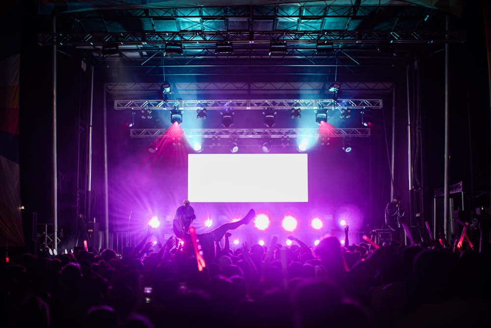 a group of people on a stage with a crowd watching