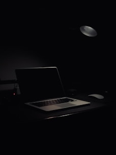 A professional coach working on a laptop in a bright, minimal office space.