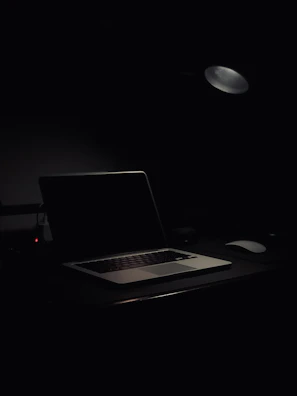A calm, softly lit workspace with a laptop open to a video call interface.