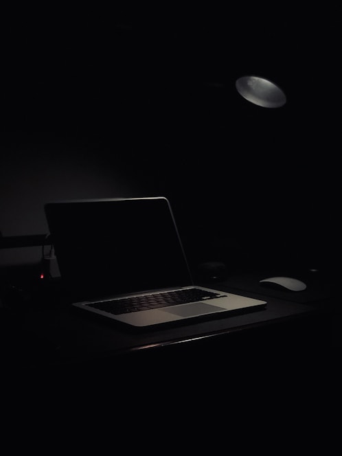 A professional coach working on a laptop in a bright, minimal office space.