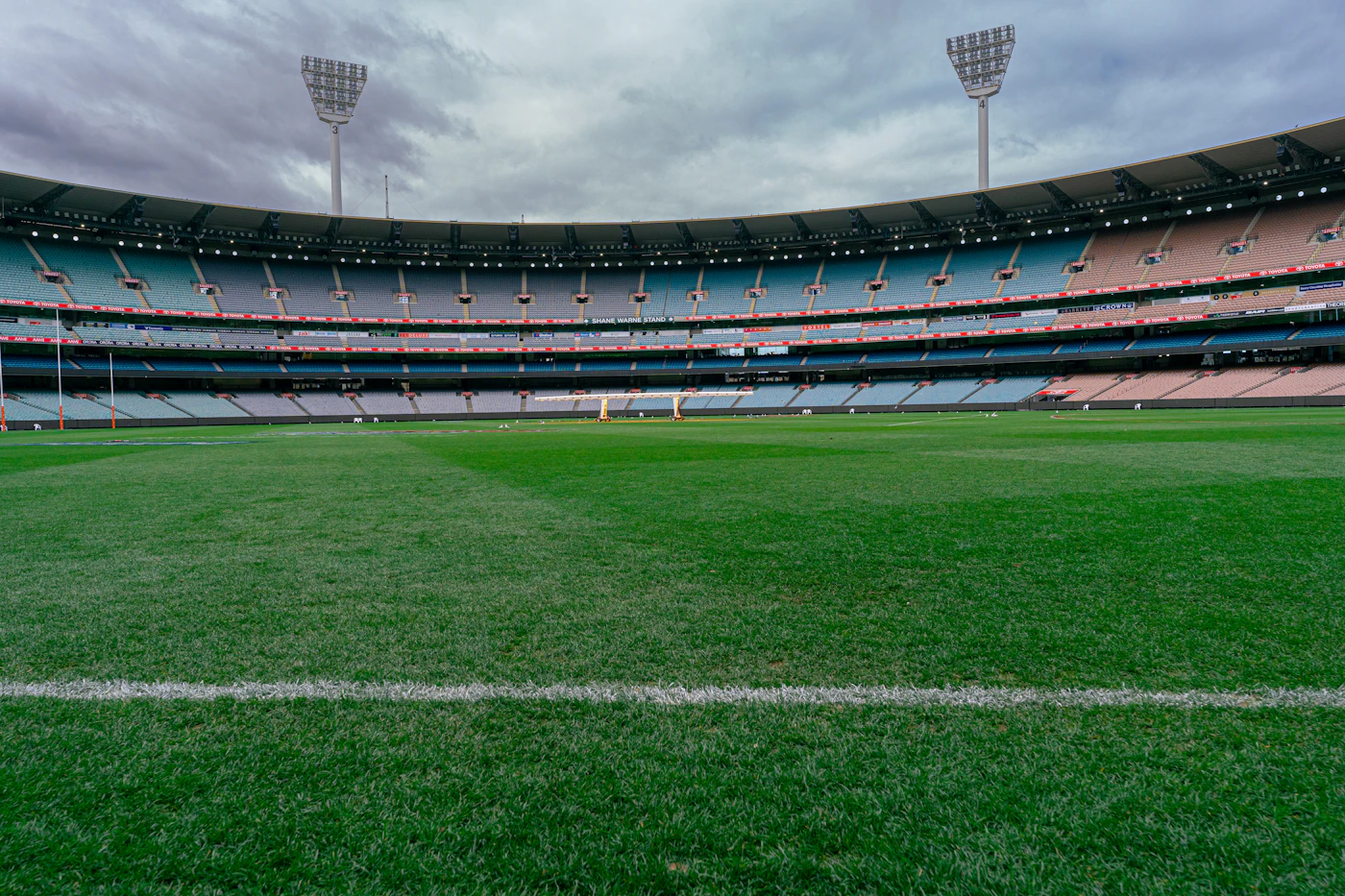 Wide view of a cricket ground with tiered seating