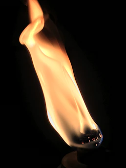 Close-up of a glowing syngas flame flickering gently in a darkened room.