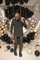 A stylish photo booth at a birthday party filled with balloons.