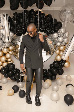 A stylish photo booth at a birthday party filled with balloons.