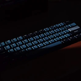 Empire branded black and gold mechanical keyboard glowing faintly against a film grain textured background.