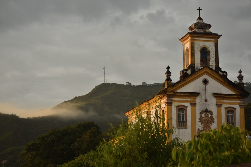 a building with a tower and a hill in the background