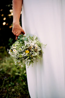 Bride holding a bouquet of wildflowers with soft sunlight