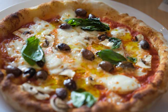 A colorful pizza topped with fresh basil, tomatoes, and mozzarella cheese.