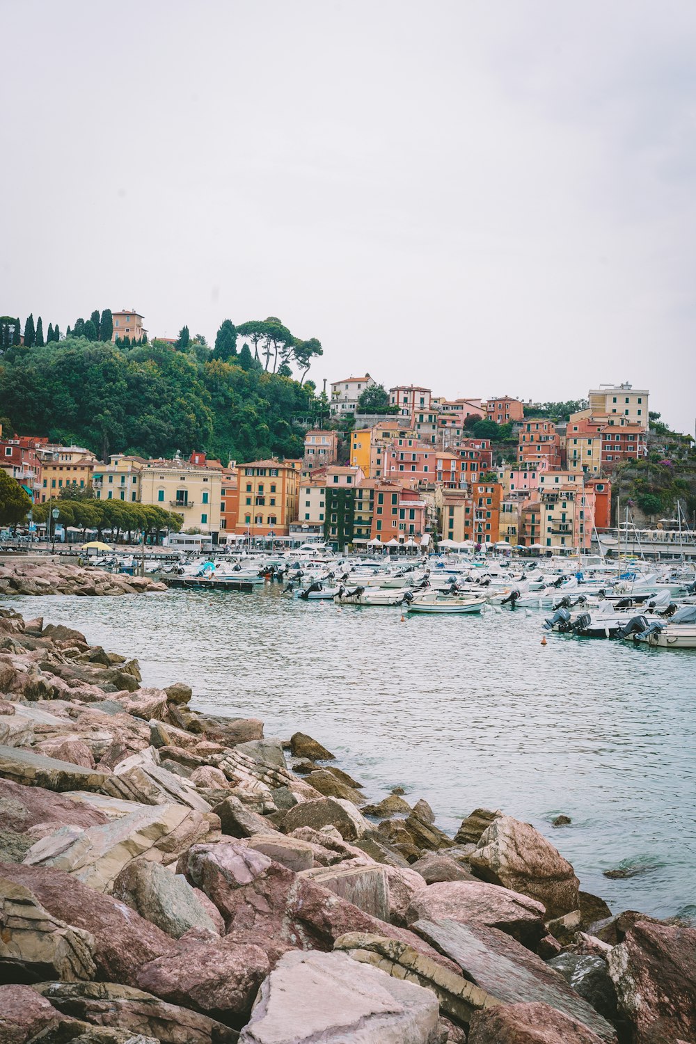 a rocky beach with boats and buildings