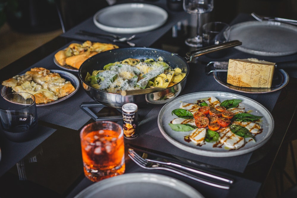 a table with plates of food and glasses of beer