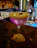 Close-up of a beautifully crafted cocktail with pink and purple hues on a stylish bar.