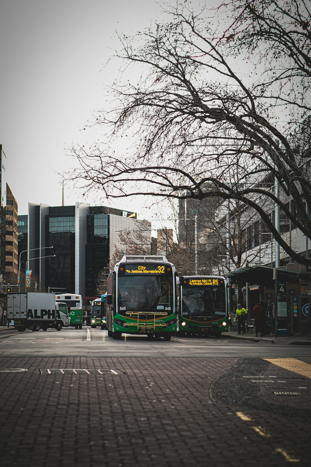 a group of buses are parked on the side of a street