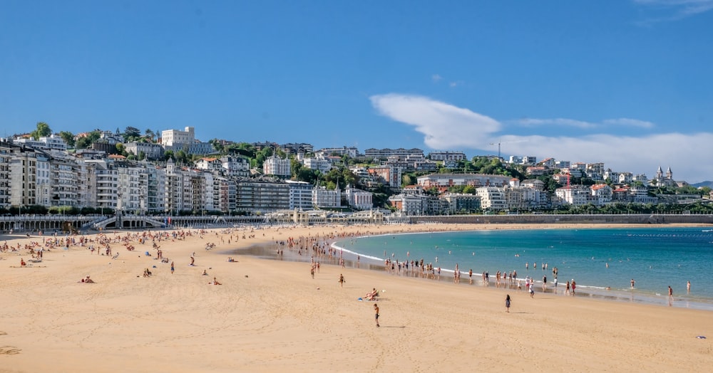 a beach with people on it and buildings in the background